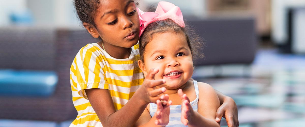 Older sister in yellow dress with little sister