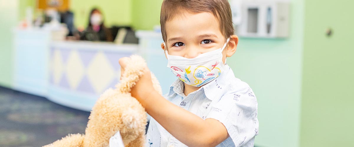Boy wearing mask and holding bunny