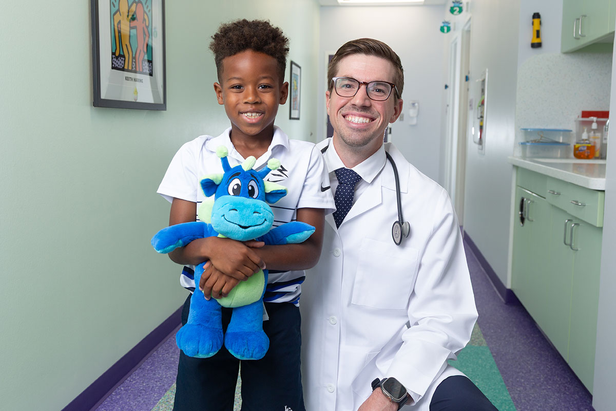 A pediatric physician at a primary care office in Anna, Texas is smiling with a kid