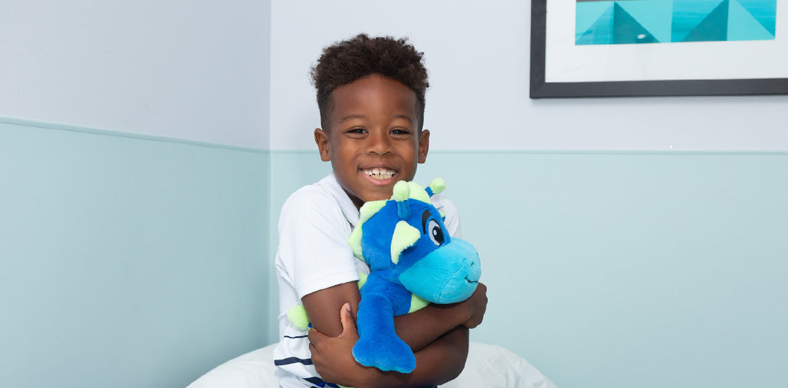 Young boy holding peaks plushie