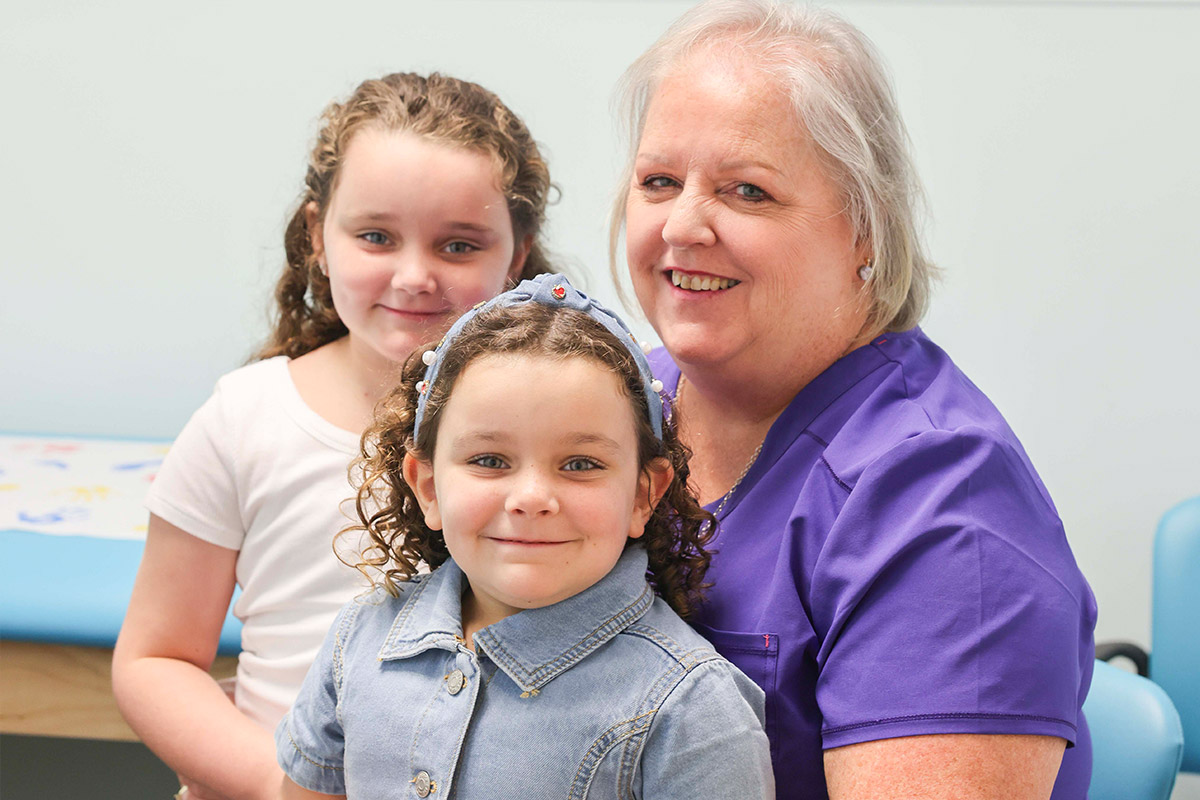 Nurse sitting with two girl patients