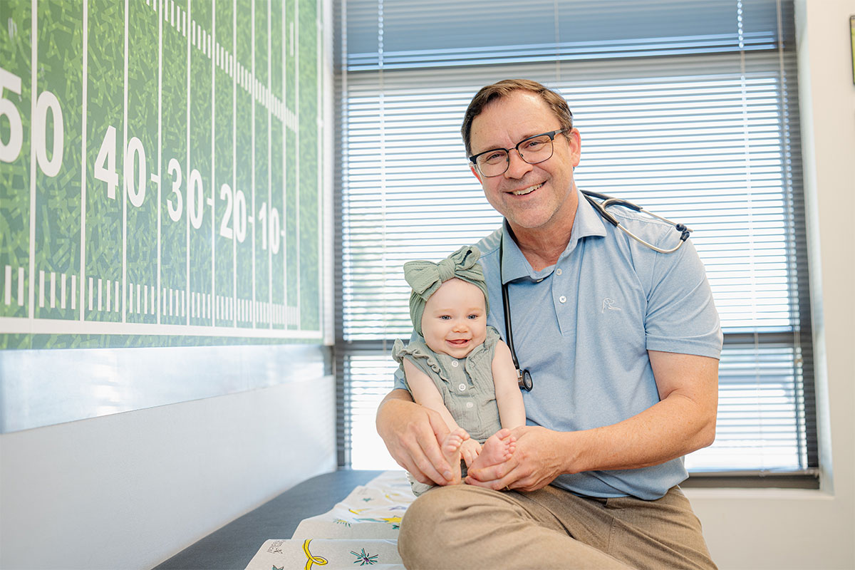 Pediatric physician holding a baby at a primary care office in Little Elm, Texas