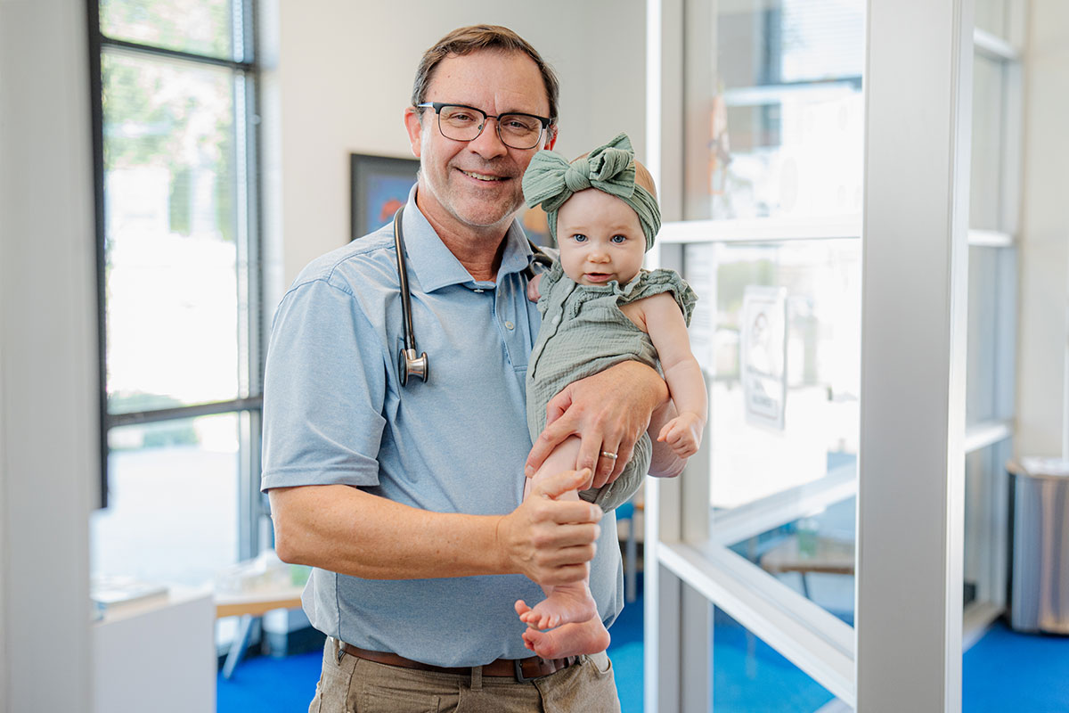 Primary care doctor smiling with a baby at a pediatric office in Little Elm, Texas