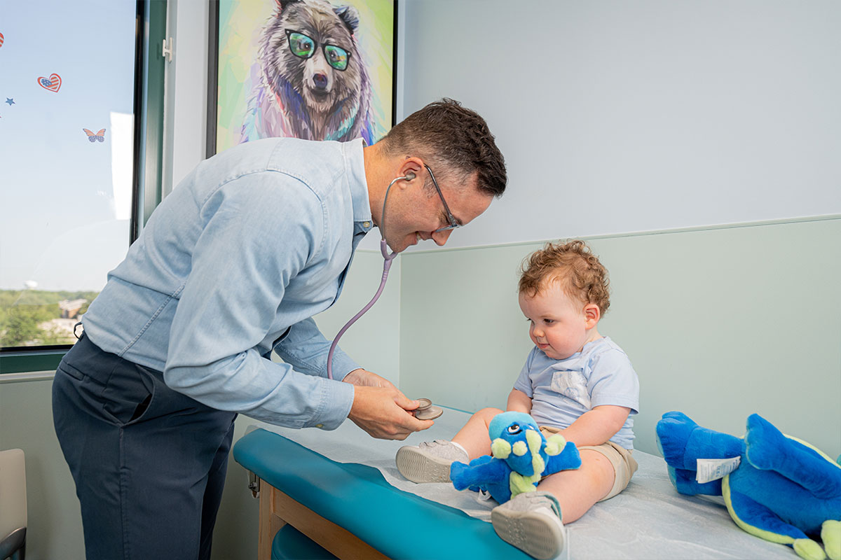 Pediatric physician examining a child's heart at a pediatric primary care office in Plano, Texas