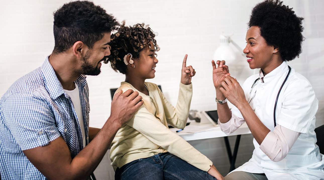 Audiologist with child and parent